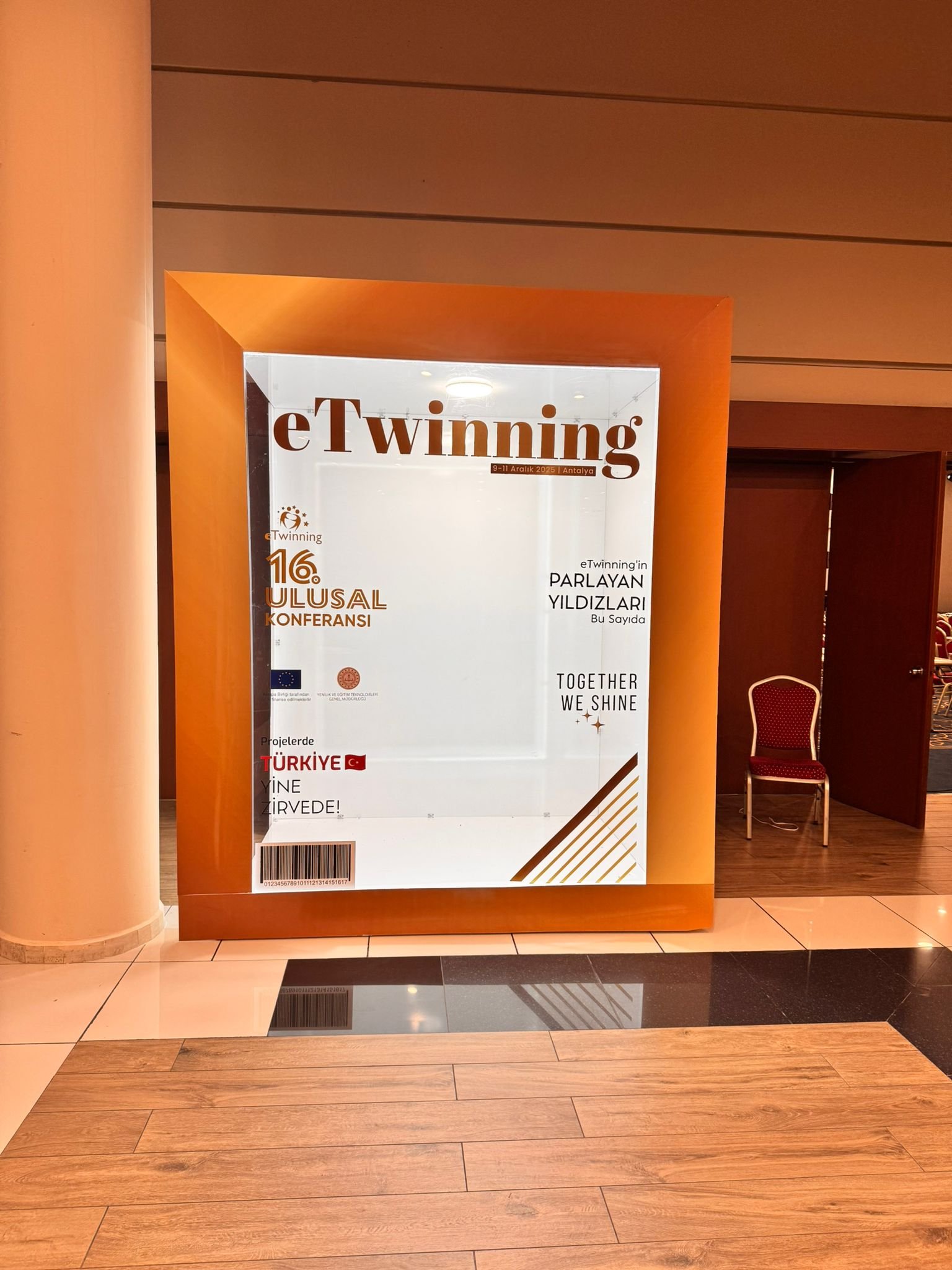 Turuncu çerçeveli, eTwinning konferansı için hazırlanmış ışıklı dev dergi kapağı şeklinde konferans fotoğraf çekim alanı.